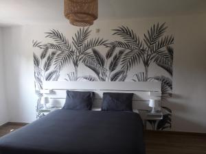 a bedroom with a bed with a mural of palm trees at Veronique schouckens in Binche