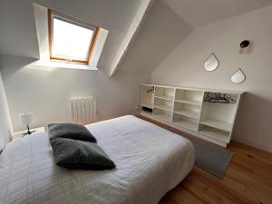 Un dormitorio con una gran cama blanca y una ventana en Le ker Maclow, en Saint-Malo