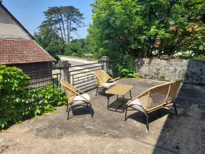 a patio with three chairs and a table and a fence at Avol d'Oiseau in Villers-Farlay