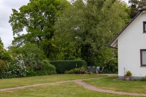 einen Hof mit einem weißen Haus und Bäumen in der Unterkunft Urlaubs-Appartement am Dorfrand in Wieck