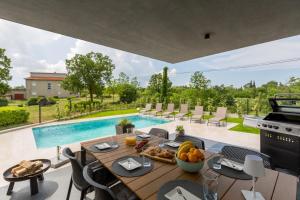 una sala da pranzo con tavolo e piscina di Villa Emma-Louisa a Žminj