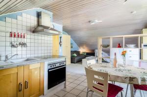 a kitchen with a table and a stove top oven at Jaulneau in Owingen