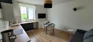 a living room with a couch and a table and a kitchen at Apartament Przy Bocznej in Kowary