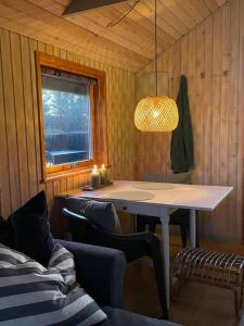 um quarto com uma mesa e cadeiras e uma janela em Skønt hus gåafstand til tornby strand em Hirtshals
