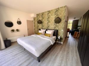 een slaapkamer met een bed met witte lakens en gele kussens bij The Roosevelt Apartments in Middelburg