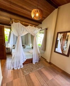 a bedroom with a bed with a canopy at Casa Del Mar in Marau