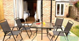 un tavolo e sedie su un patio con un cesto di frutta di Cambridge Stays 4BR House-Garden-Lots of Parking-15 min to city-Close to motorway a Girton