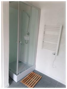 eine Glasduschkabine mit einer hölzernen Plattform im Bad in der Unterkunft Studio Le Jardin in Tournon-sur-Rhône