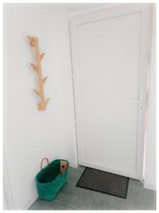 eine weiße Tür mit einem Korb daneben. in der Unterkunft Studio Le Jardin in Tournon-sur-Rhône