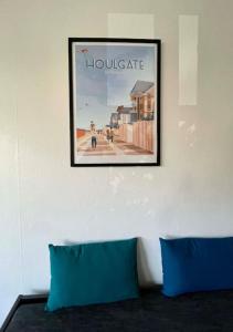 a picture hanging on a wall with two blue pillows at Studio Le Pied à Mer in Houlgate +8 photos