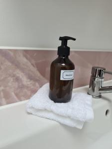 a bottle of soap sitting on top of a bathroom sink at Palm Cottage in Kent