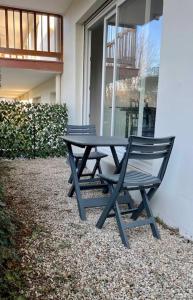 a picnic table and bench in front of a building at Studio Le Pied à Mer in Houlgate