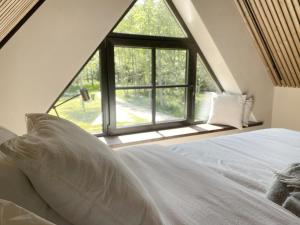 a bedroom with a bed with a large window at Heinaläku puhkemaja loft in Paope