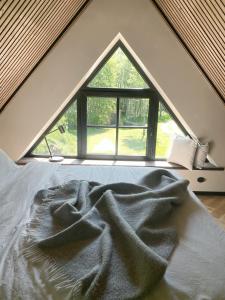 a bed in a room with a large window at Heinaläku puhkemaja loft in Paope