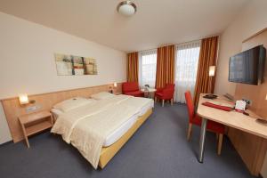 a hotel room with a large bed and a desk at Hotel Filderland - Stuttgart Messe - Airport - Self Check-In in Leinfelden-Echterdingen