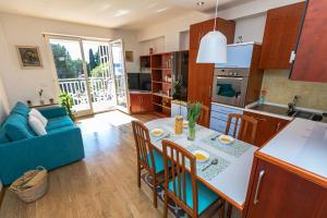 a kitchen and living room with a table and a blue couch at Sea & Me, pleasant seaside home in Portorož