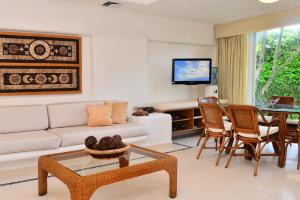 a living room with a couch and a table at Las Villas Akumal in Akumal