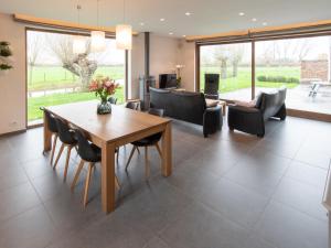 ein Wohnzimmer mit einem Holztisch und Stühlen in der Unterkunft heyzerhof in Poperinge