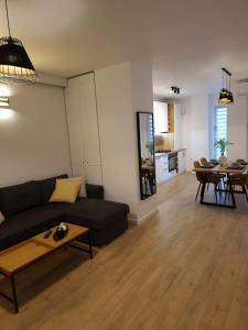 ein Wohnzimmer mit einem Sofa und einem Tisch in der Unterkunft Oak Apartment lovely one bedroom apartment at Columna Residence near Vivo mall in Cluj-Napoca