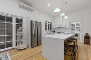 a white kitchen with a refrigerator and a counter at Picture Perfect Create timeless treasures in Perth