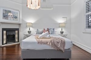 uma mulher deitada numa cama num quarto em Picture Perfect Create timeless treasures em Perth