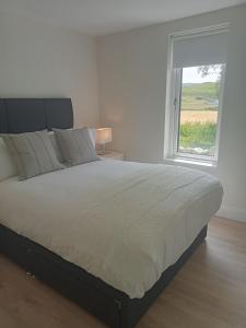 a bedroom with a large bed and a window at The Cottage - Fairwinds in Doolin