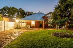 une maison en briques avec une clôture et une cour dans l'établissement Picture Perfect Create timeless treasures, à Perth