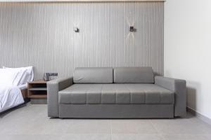 eine Couch in einem Zimmer neben einem Bett in der Unterkunft Notos Premium Holiday Apartments in Pefkohori