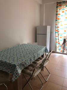 uma cozinha com uma mesa e cadeiras e um frigorífico em Alcantara Apartment em Gaggi