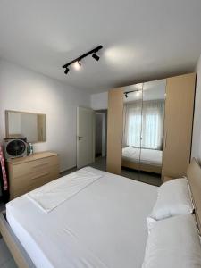 a bedroom with a large white bed and a mirror at Seaview Apartment in Dhërmi +11 photos
