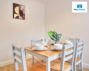 a dining room table with chairs and a white table and chairsktop at Four Bedroom By Keysleeps Short Lets Peterborough With Free Parking Spacious Central Contractor in Peterborough