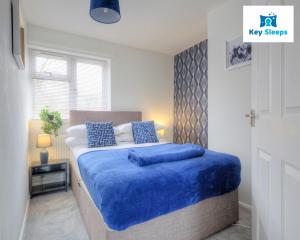 a bedroom with a large bed with blue sheets at Four Bedroom By Keysleeps Short Lets Peterborough With Free Parking Spacious Central Contractor in Peterborough