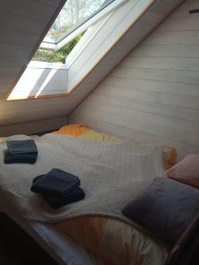 a bed in a room under a roof with a window at Ozierański Eden "Pod rzeźbami" 