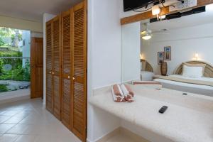 a bathroom with a sink and a bedroom with a bed at Las Villas Akumal in Akumal