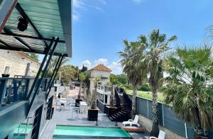 un balcón de una casa con piscina y palmeras en Mas La Farelle Chambre d'hote,Fitness & Salle de jeux Gratuite & SPA en supplément, en Nimes