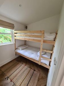 two bunk beds in a room with a window at Palm Cottage in Kent