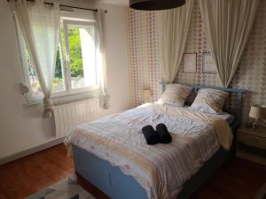 Un dormitorio con una cama con dos zapatos negros. en Appartement Cocooning, en Ars-sur-Moselle