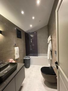 uma casa de banho com um WC preto, um lavatório e uma banheira em 6BR SEA SALT POOL PRİVATE VİLLA em Sarıyer