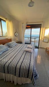 a bedroom with a bed with a view of the ocean at Hostal Galapagos by Bar de Beto in Puerto Villamil