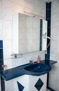 ein Badezimmer mit einem blauen Waschbecken und einem Spiegel in der Unterkunft Terrassenhotel Seepromenade in Edersee