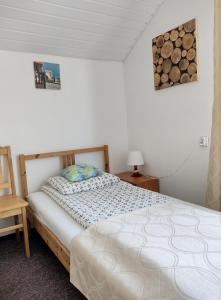 1 dormitorio con cama y silla de madera en Satori, en Władysławowo