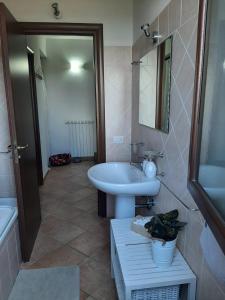 y baño con lavabo blanco y bañera. en A casa di Miele en Campagnano di Roma