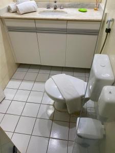 a bathroom with a toilet and a sink at Apart Flat Farol da Barra in Salvador