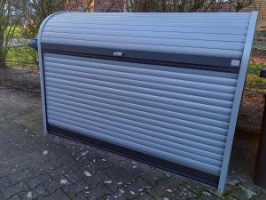 a large metal garage door sitting on a sidewalk at Fewo Rietberg in Rietberg +7 photos