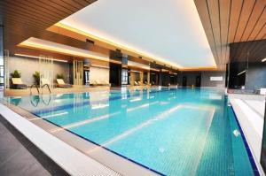 a large swimming pool in a building with a large pool at Trendy Cool Bright Studio Parking Poolviews! #254 in Istanbul