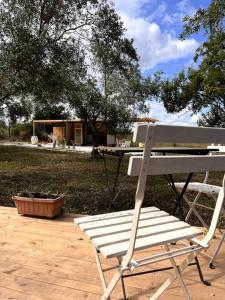 un banco blanco sentado en un patio con una mesa en La ViTa in land - between olives and almonds, en Noto