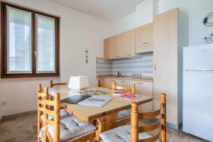 a kitchen with a wooden table and a refrigerator at Villetta al Torchio Artemide in Manerba del Garda