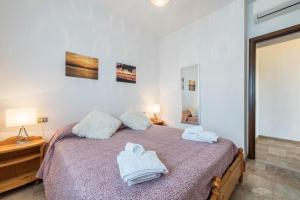 a bedroom with a bed with towels on it at Villetta al Torchio Artemide in Manerba del Garda
