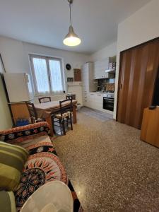 ein Wohnzimmer mit einem Sofa und einem Tisch sowie eine Küche in der Unterkunft A CASA DI NONNA LUISA in Porto San Giorgio