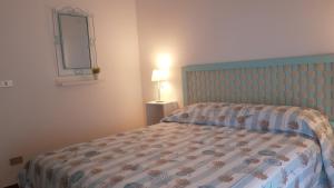 a bedroom with a bed with a blue headboard and a mirror at Casa gialla Silvi Marina in Silvi Marina